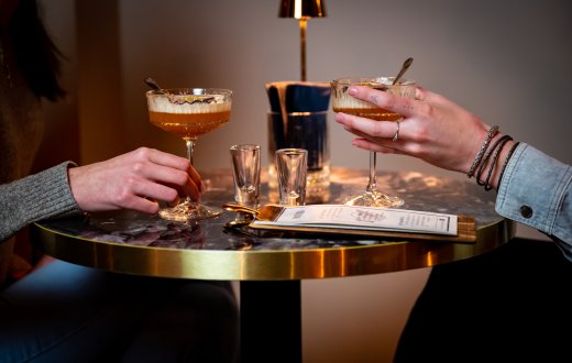 2 mensen houden glazen vast met cocktails